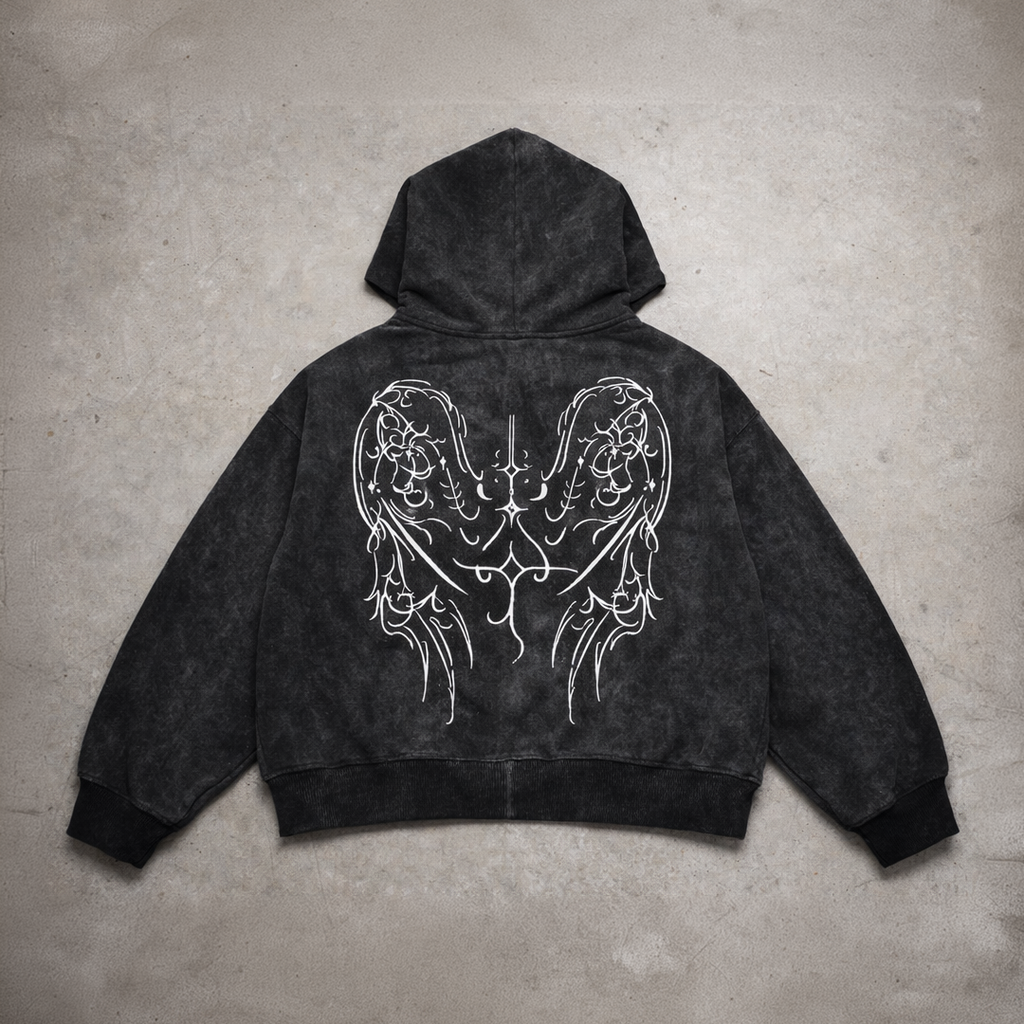 Black hoodie with white angel wings design on a concrete floor